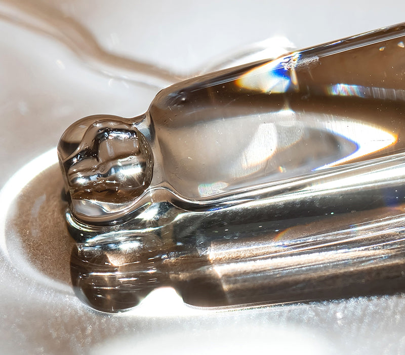 Zoomed in clear liquid with a glass dropper